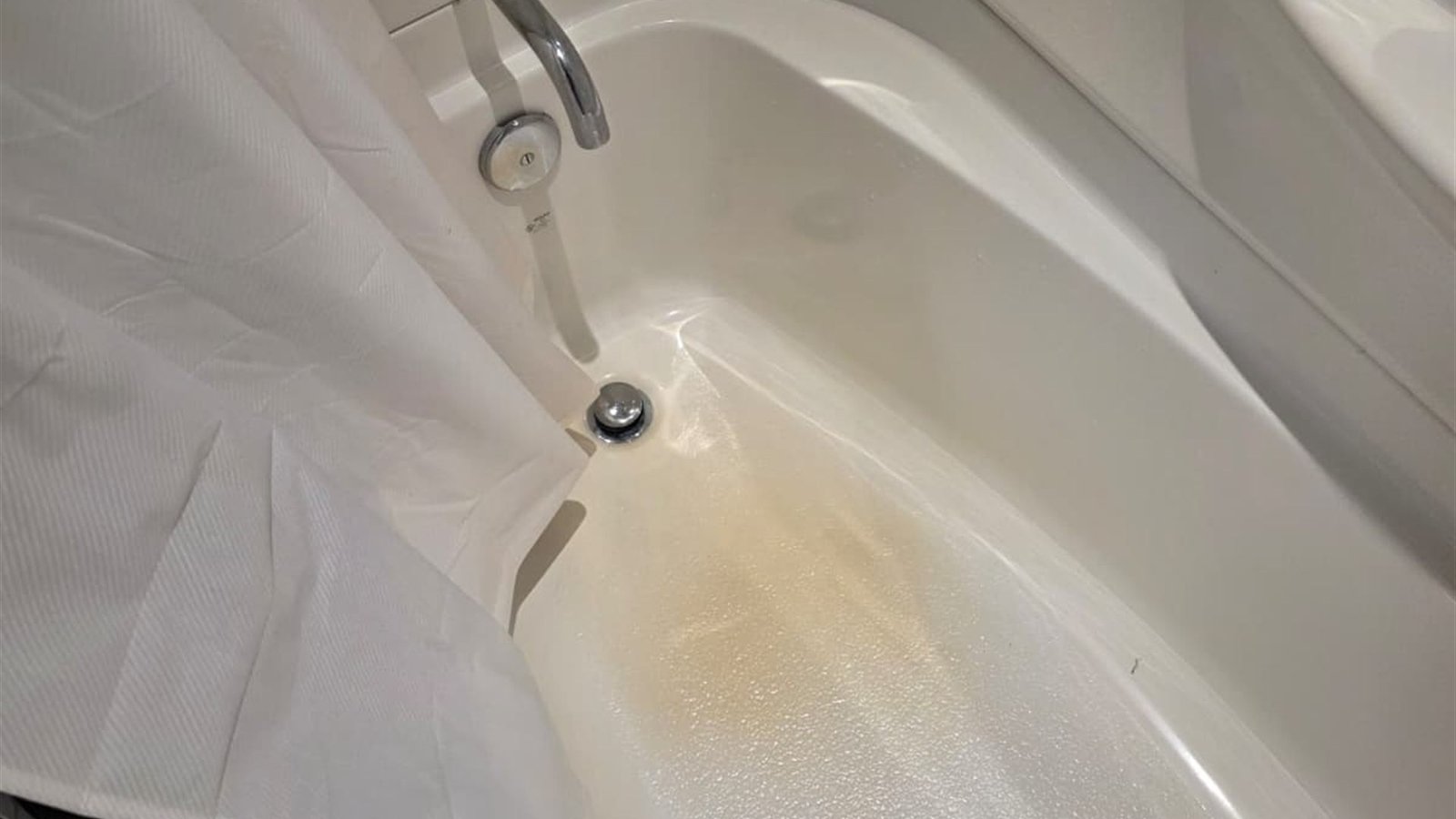 The same tub before cleaning, with heavy mineral staining